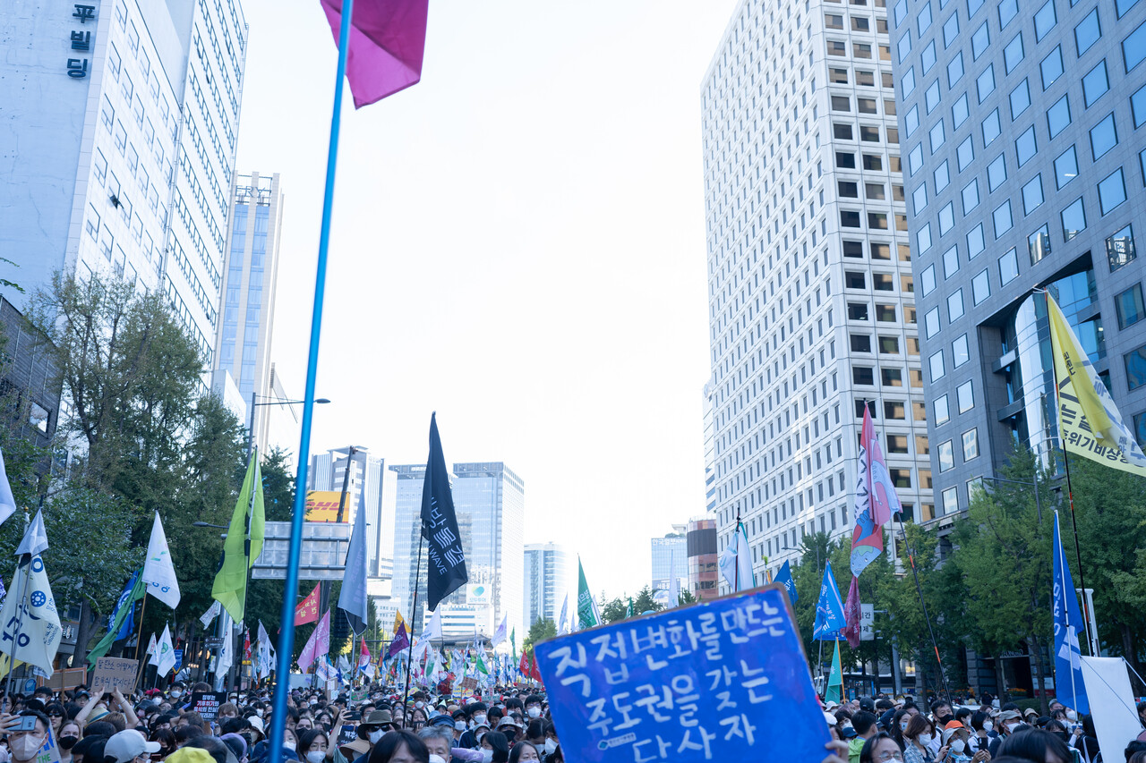 "직접 변화를 만드는 주도권을 갖는 당사자"라고 적힌 피켓 뒤로, 행진에 참여한 시민들의 모습 (사진 : 김연웅 기자)