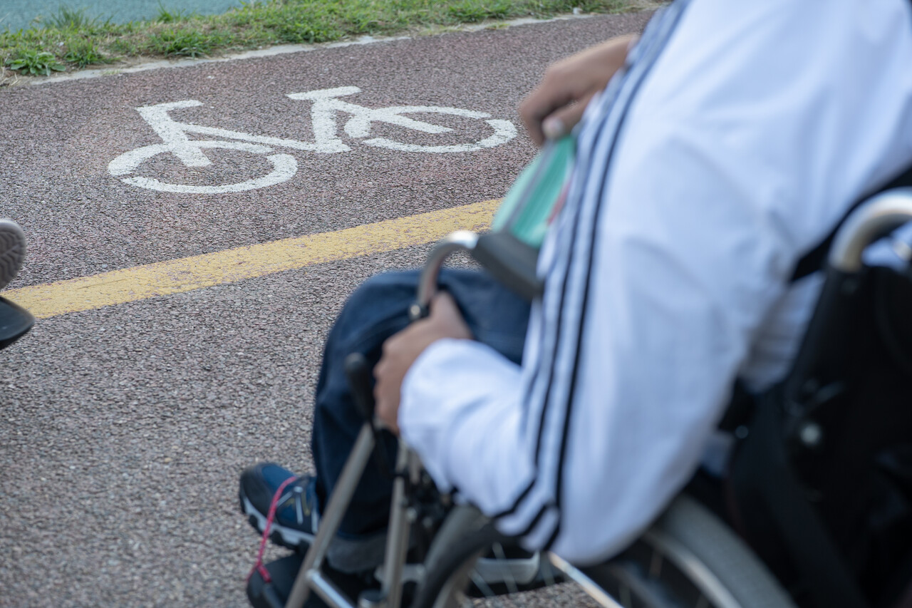 휠체어의 산책로 접근이 제한되어 자전거도로 위에 서있는 모습 (사진 : 김연웅 기자)