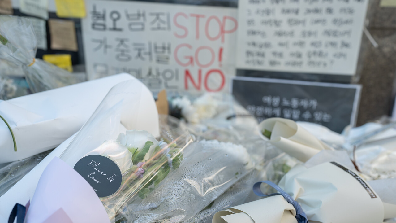 신당역 추모 공간에 쌓여있는 헌화들 뒤로 보이는 시민들의 메모 (사진 : 김연웅 기자)
